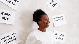 Portrait of a smiling woman surrounded by health motivation signs on a white background, promoting a healthy lifestyle.
